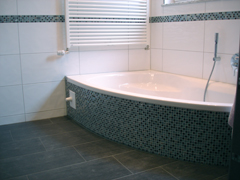 Eckbadewanne mit Mosaikplatten verkleidet